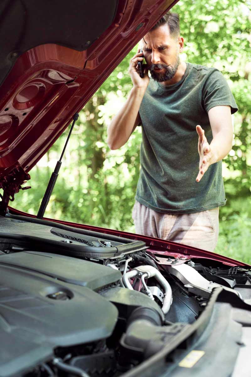 Junger Mann prüft Getriebeschaden bei Schrottauto Ankauf Baesweiler